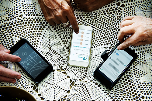 Senior hands using mobile phones on a table
