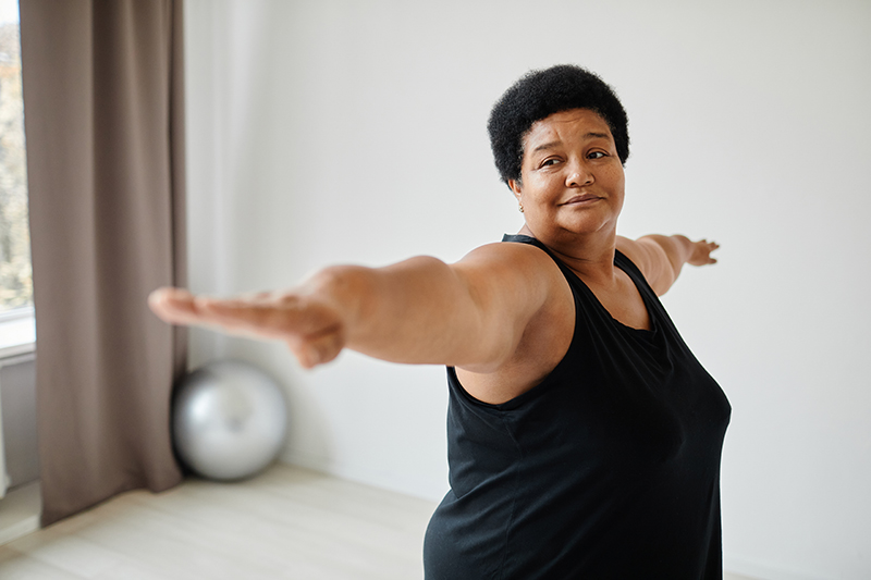 Minimal waist up portrait of active senior woman working out indoors and stretching